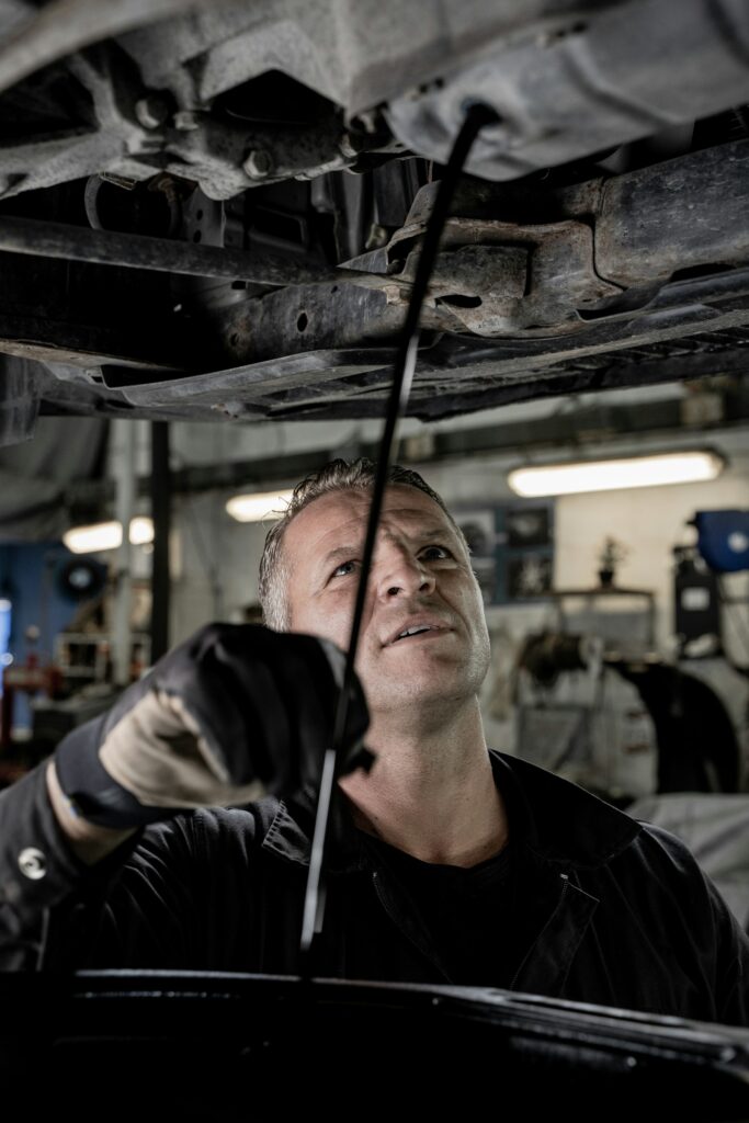 Mechanic working underneath a car in a garage